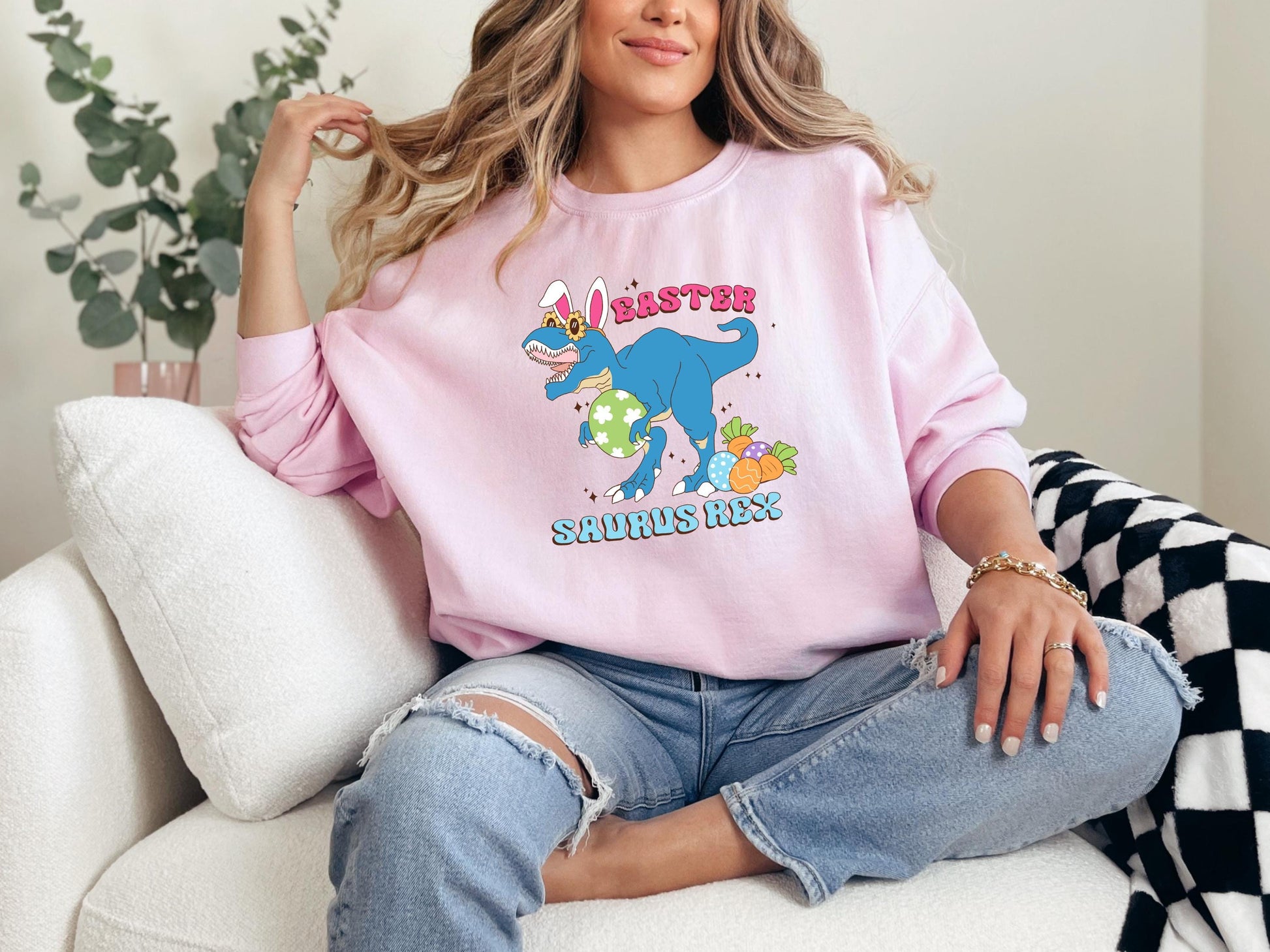 a woman sitting on a couch wearing a pink shirt