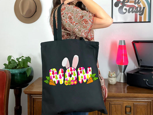 a woman holding a black bag with the word bunny painted on it