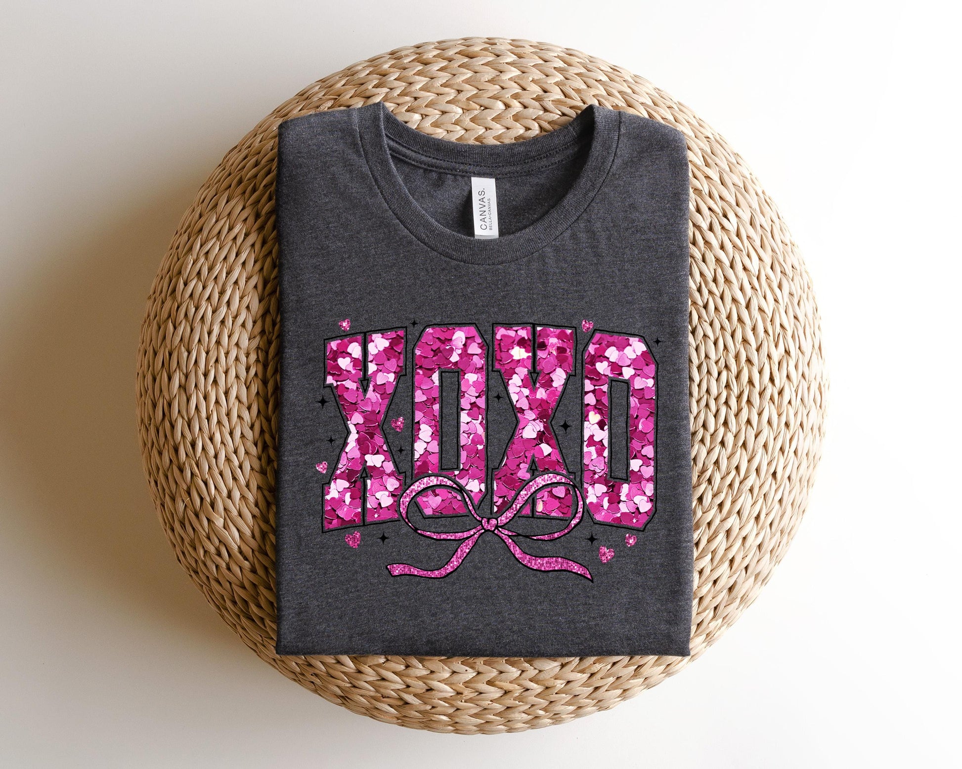 a gray shirt with pink letters and a bow
