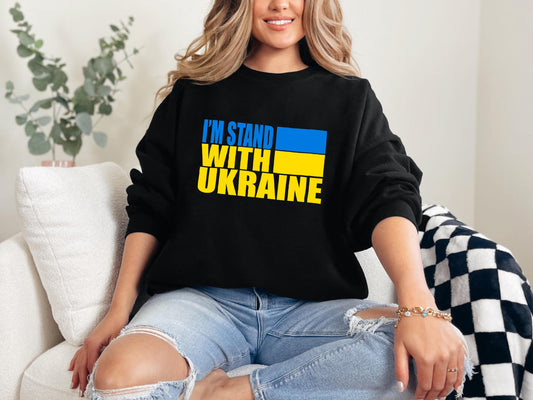 a woman sitting on a couch wearing a black sweatshirt that says i&#39;m stand