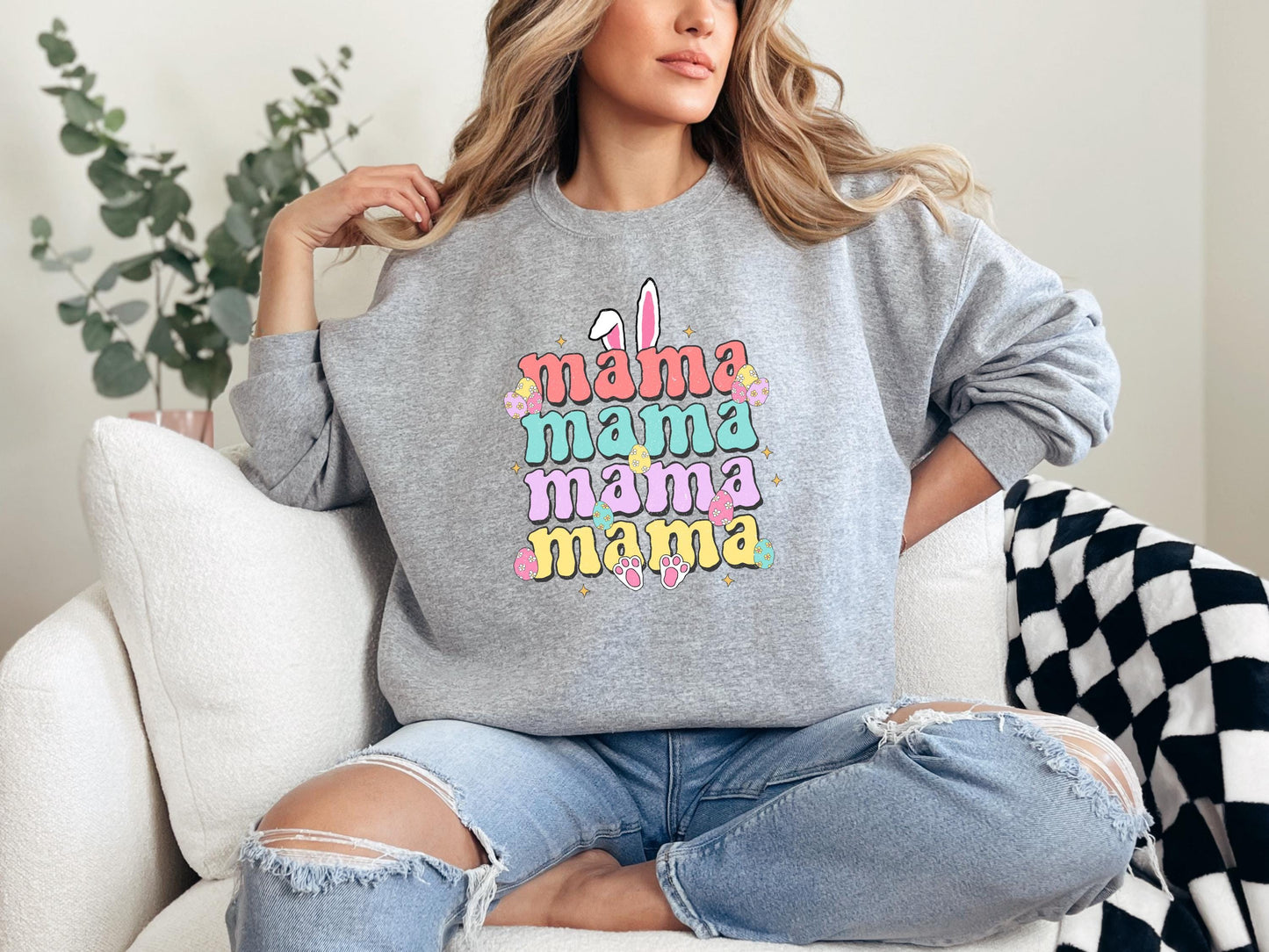 a woman sitting on a couch wearing a grey sweatshirt