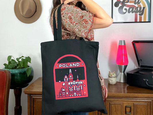 a woman holding a black bag with a picture on it