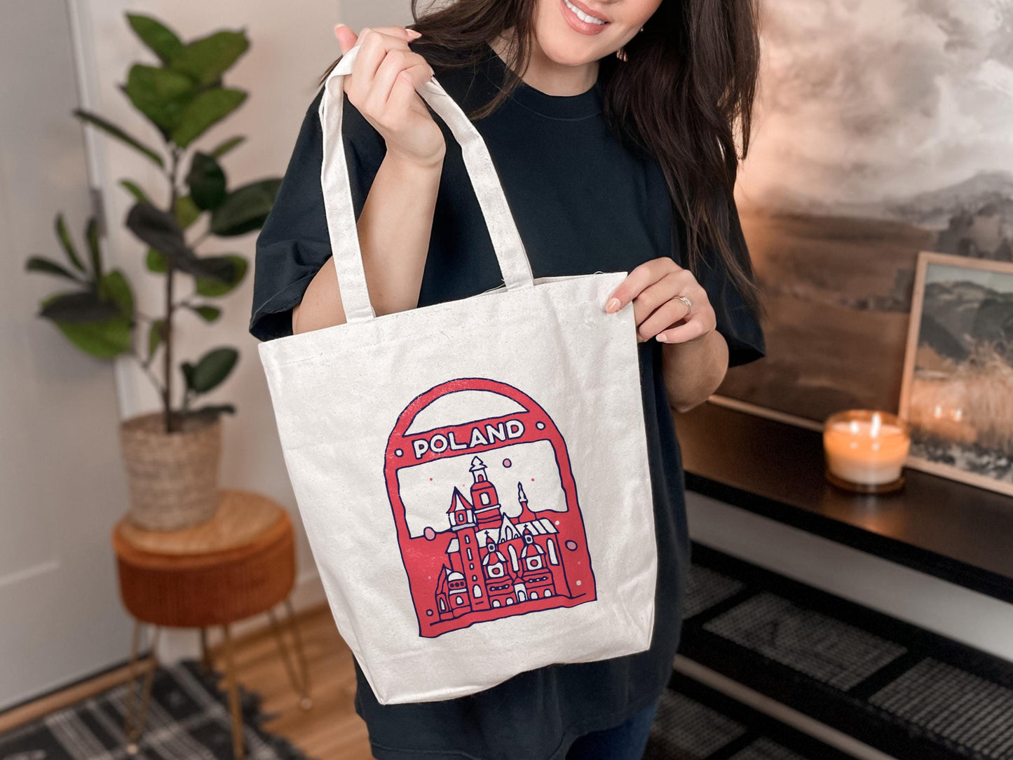 a woman holding a bag with a picture of a castle on it