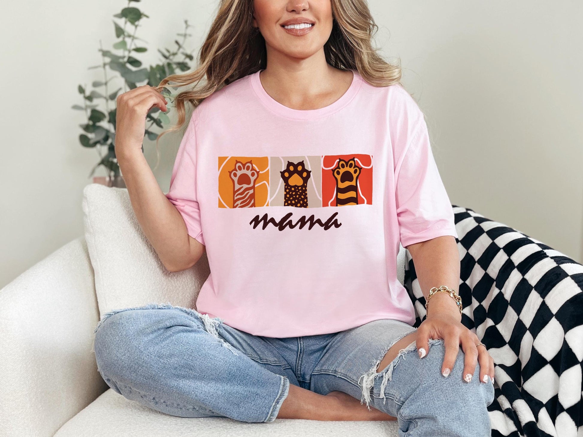 a woman sitting on a couch wearing a pink shirt
