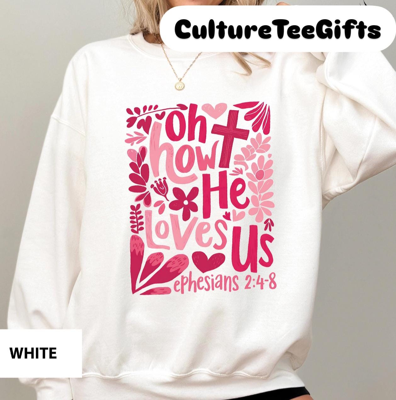 a woman wearing a white sweatshirt with pink lettering on it