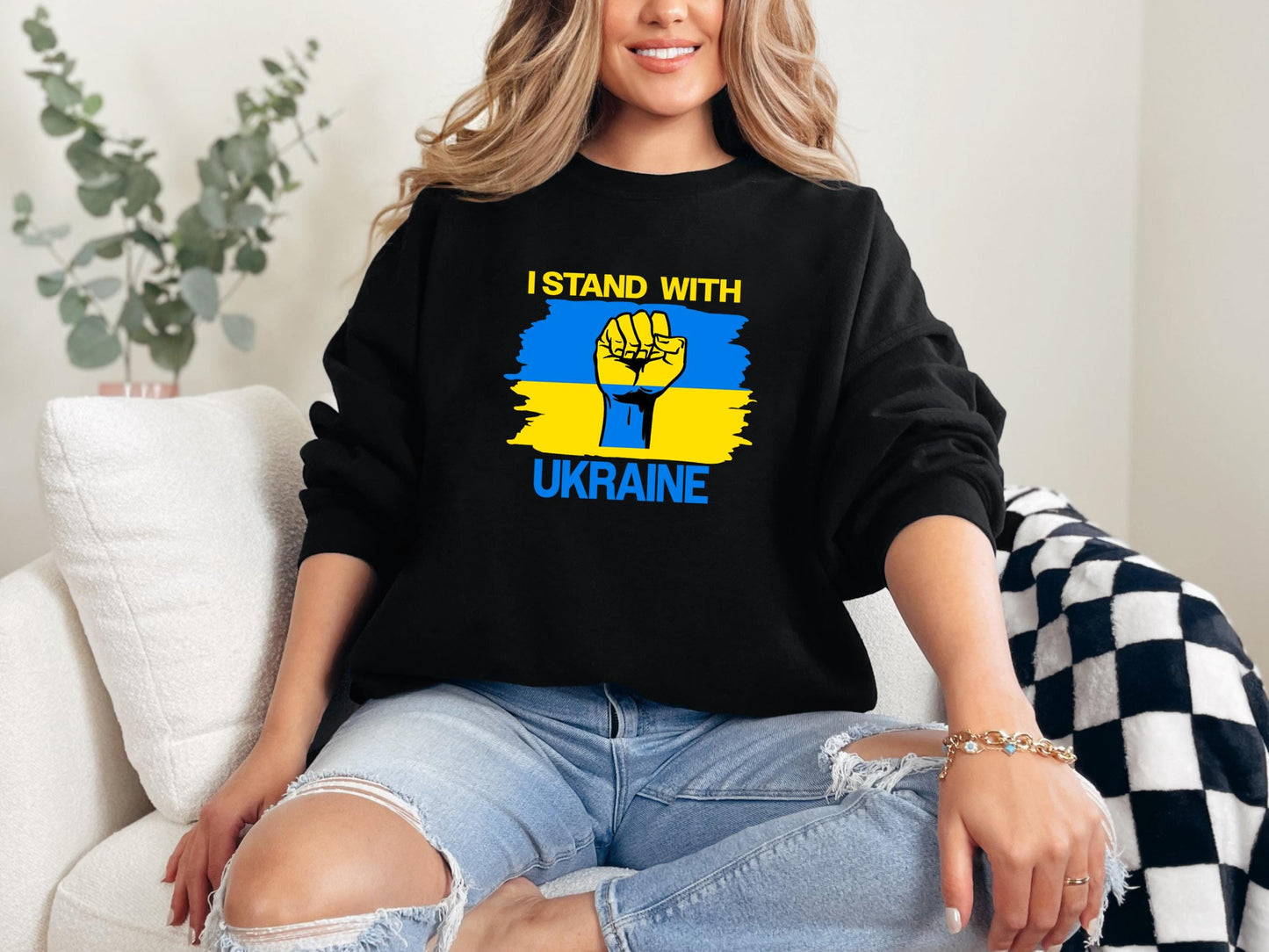 a woman sitting on a couch wearing a black sweatshirt