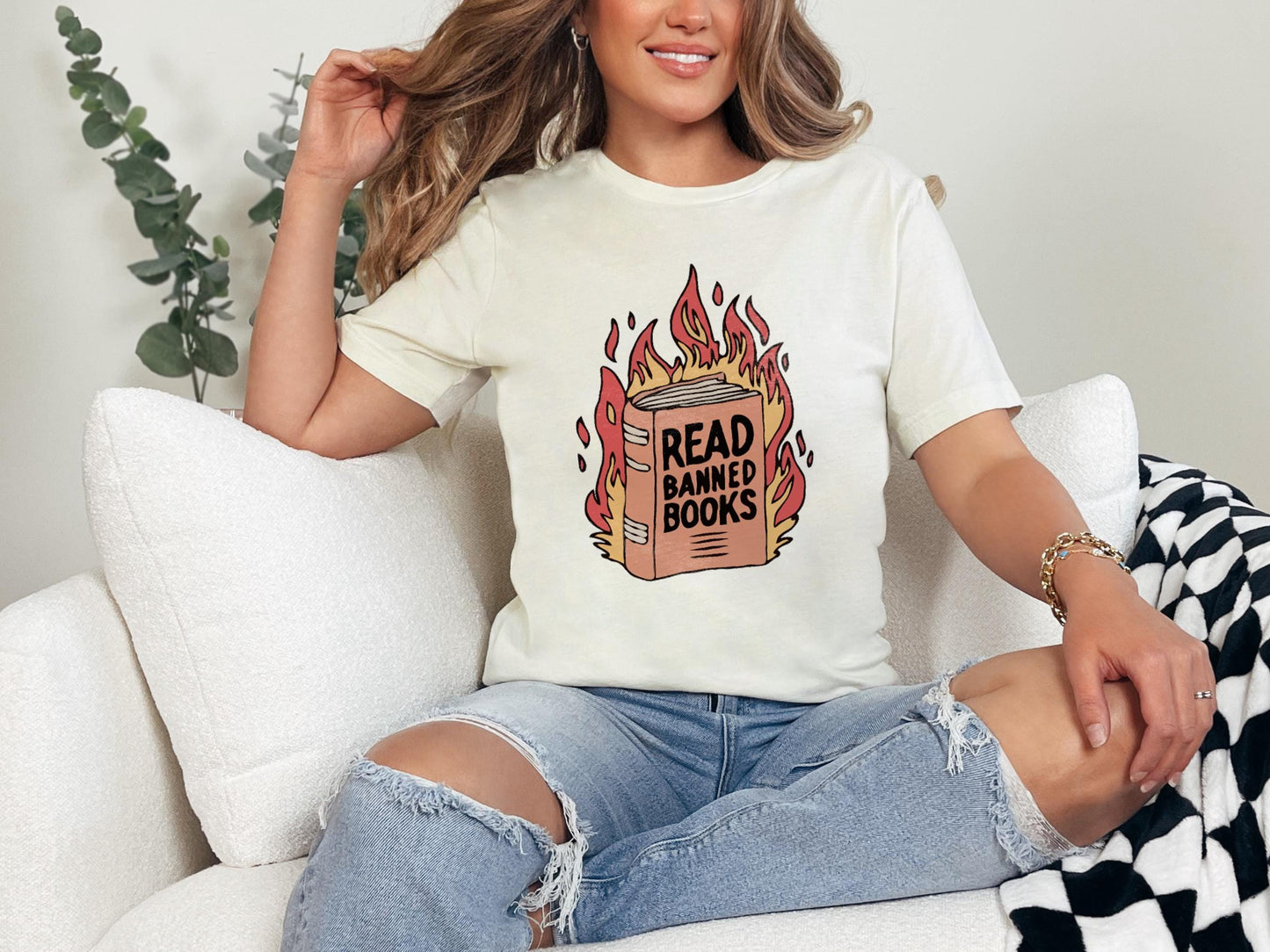 a woman sitting on a couch wearing a t - shirt that reads read bang bang