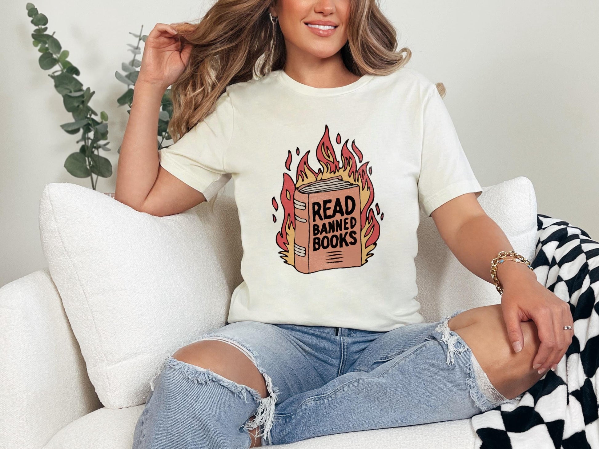 a woman sitting on a couch wearing a t - shirt that reads read bang bang