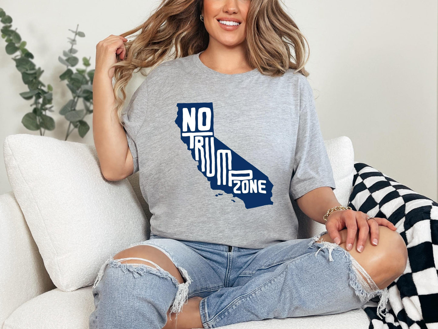 a woman sitting on a couch wearing a t - shirt with the state of california