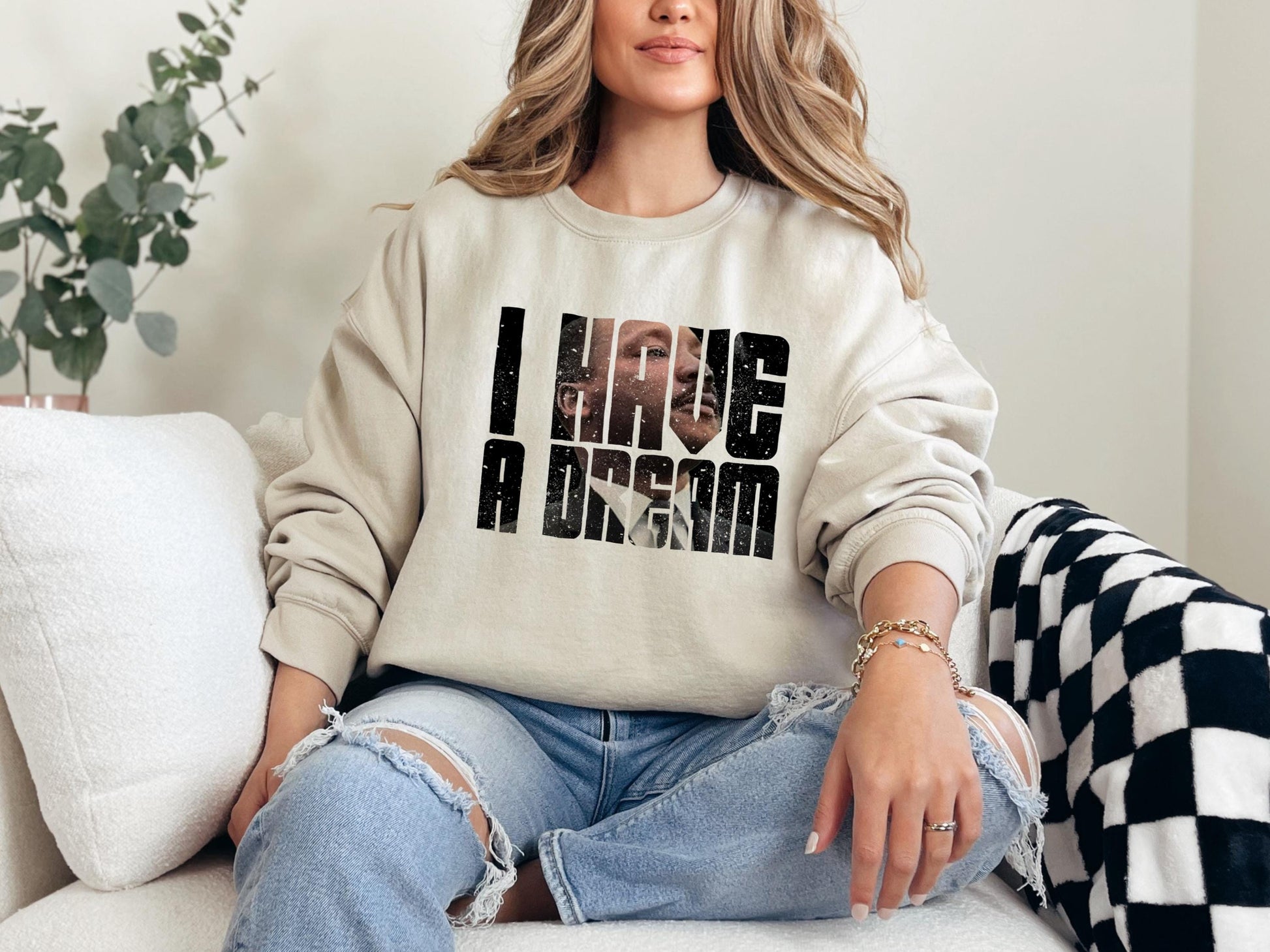 a woman sitting on a couch wearing a sweatshirt