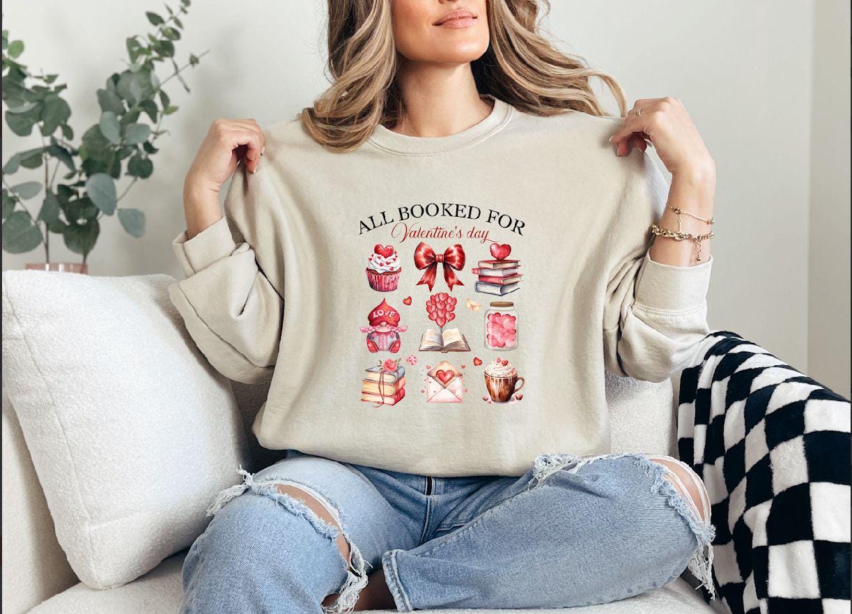 a woman sitting on a couch holding up a sweater