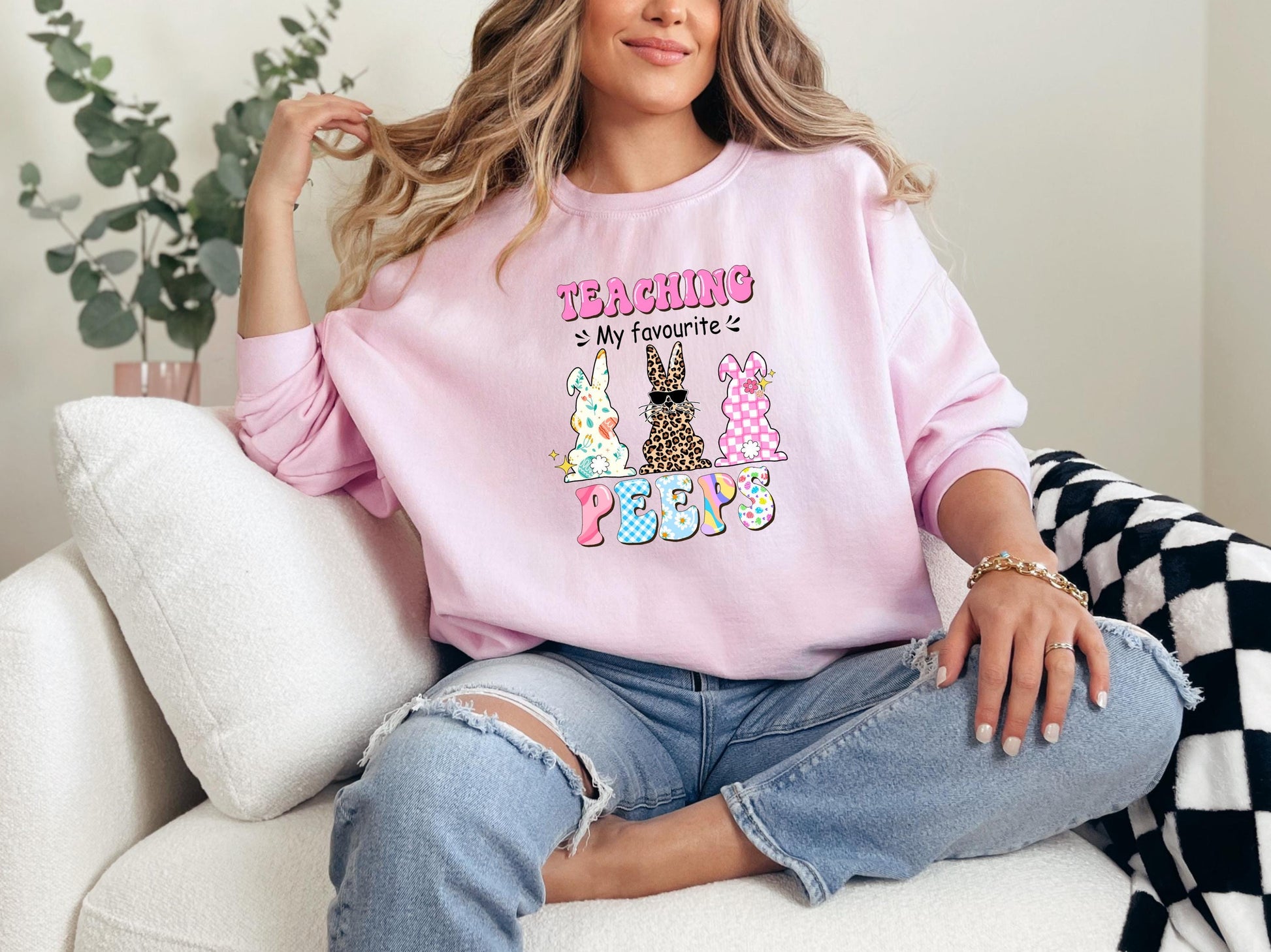 a woman sitting on a couch wearing a pink shirt