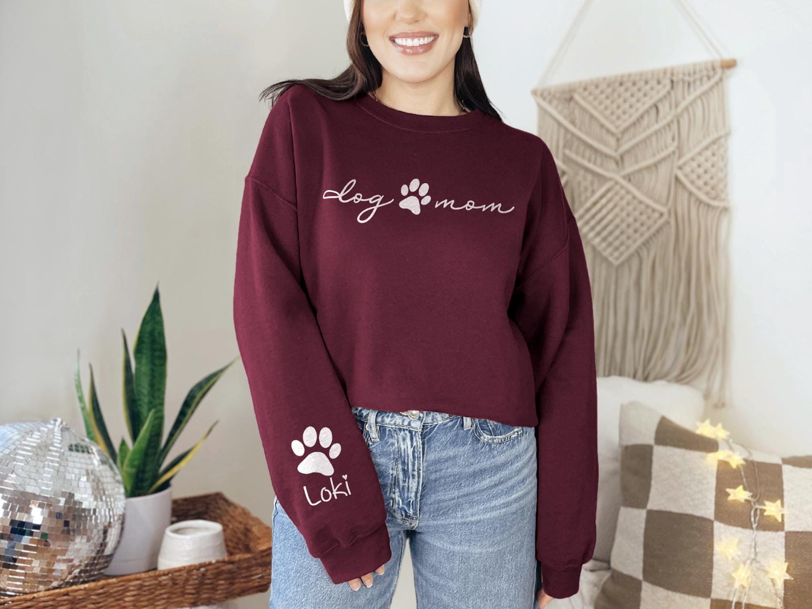 a woman wearing a red sweatshirt with a dog paw on it
