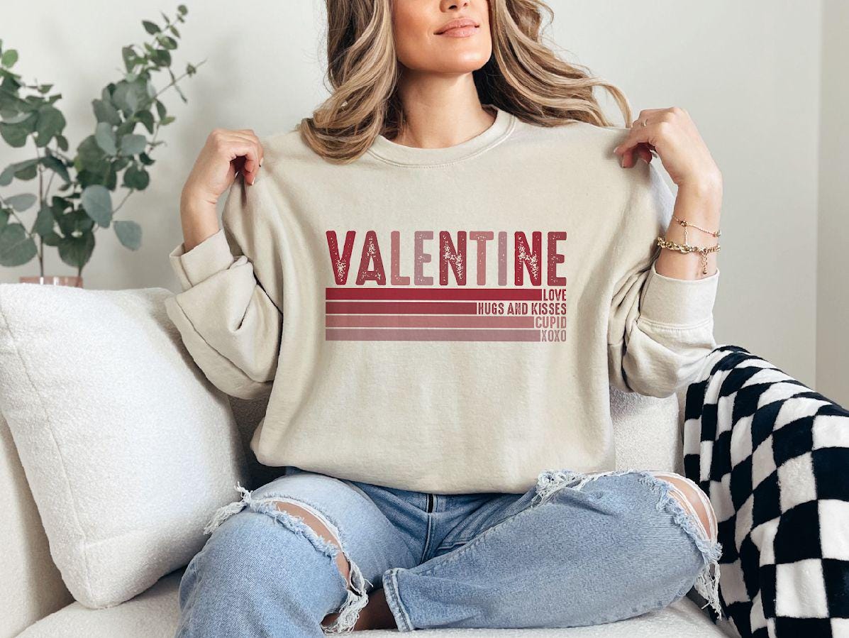 a woman sitting on a couch holding onto a sweater