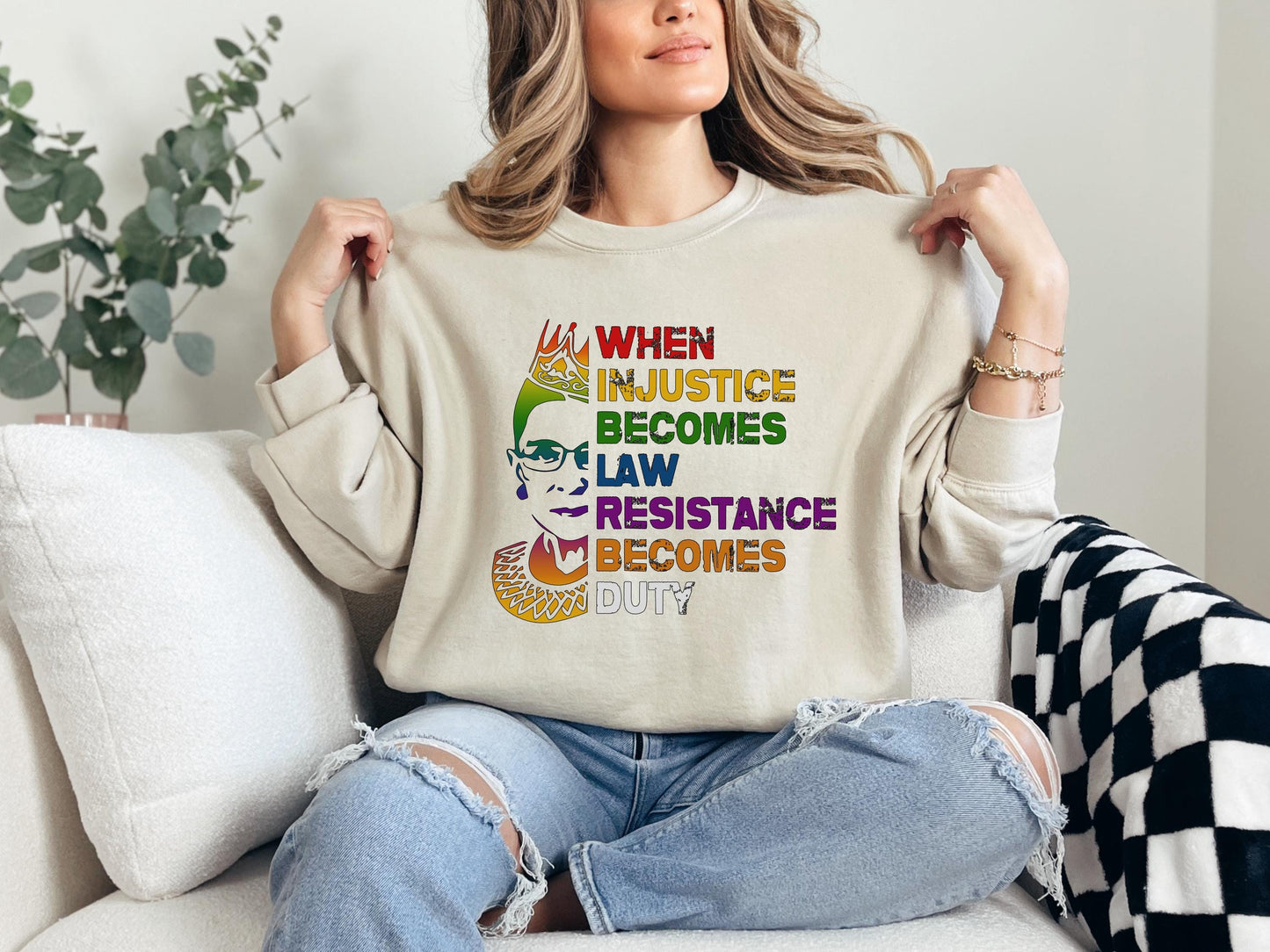 a woman sitting on a couch holding up a t - shirt