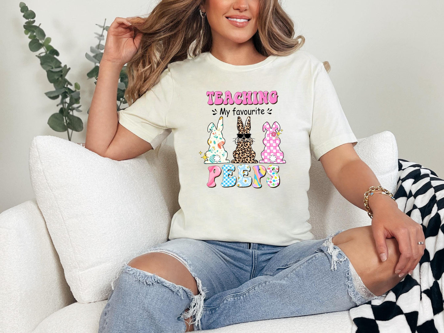 a woman sitting on a couch wearing a t - shirt