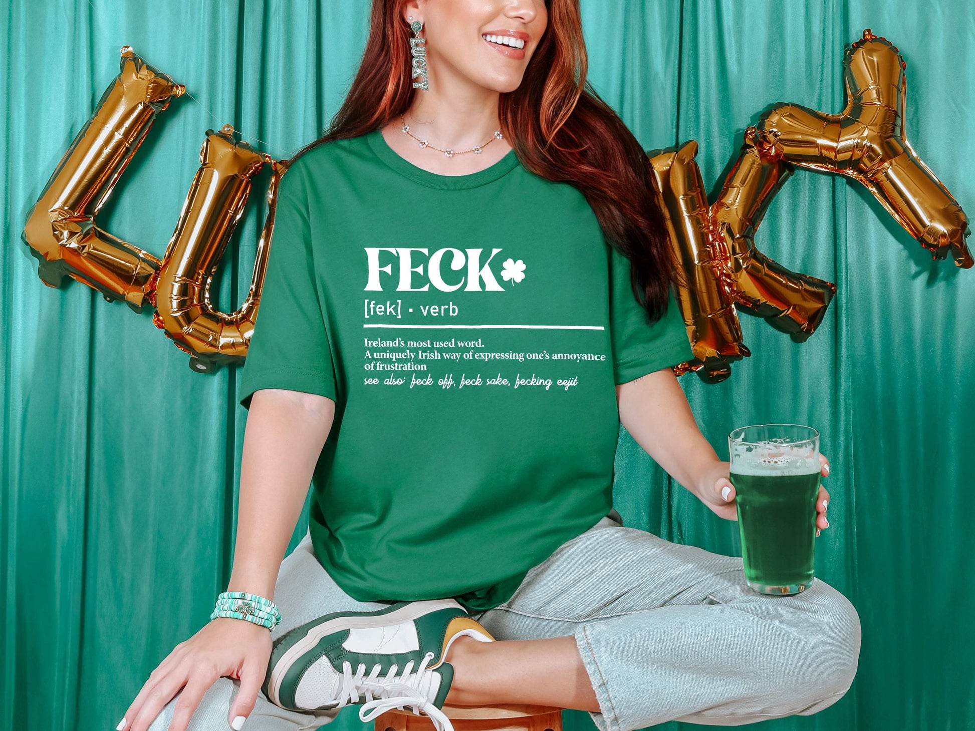 a woman sitting on a stool holding a glass of beer