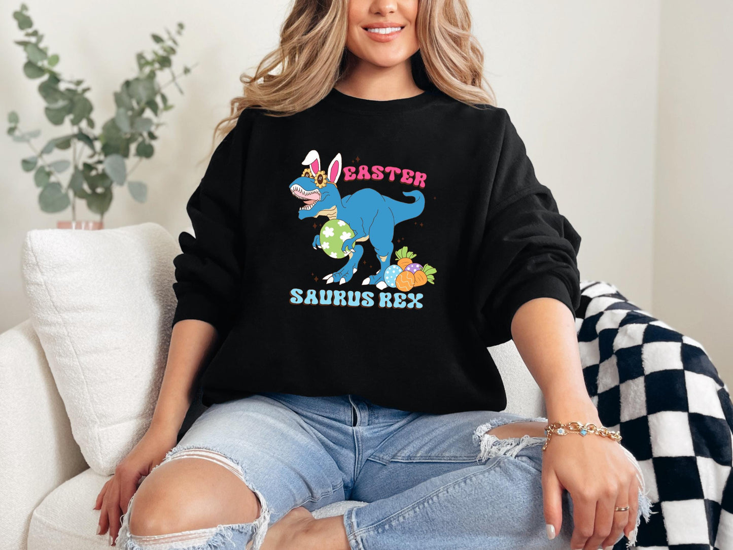 a woman sitting on a couch wearing a black sweatshirt