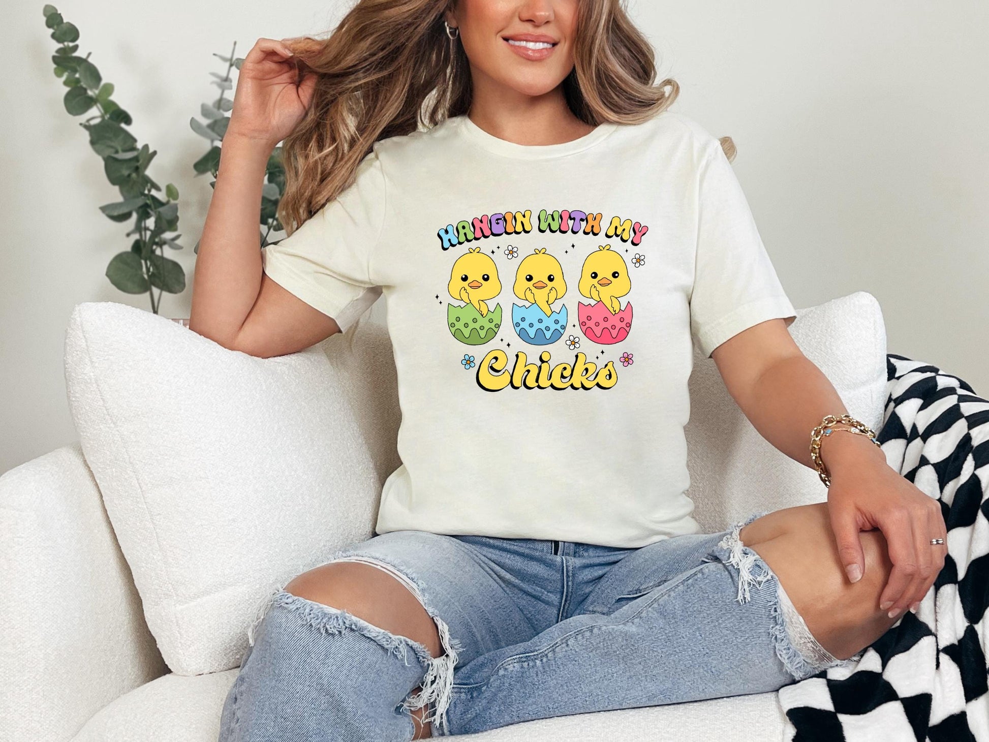 a woman sitting on a white couch wearing a t - shirt that says happy birthday