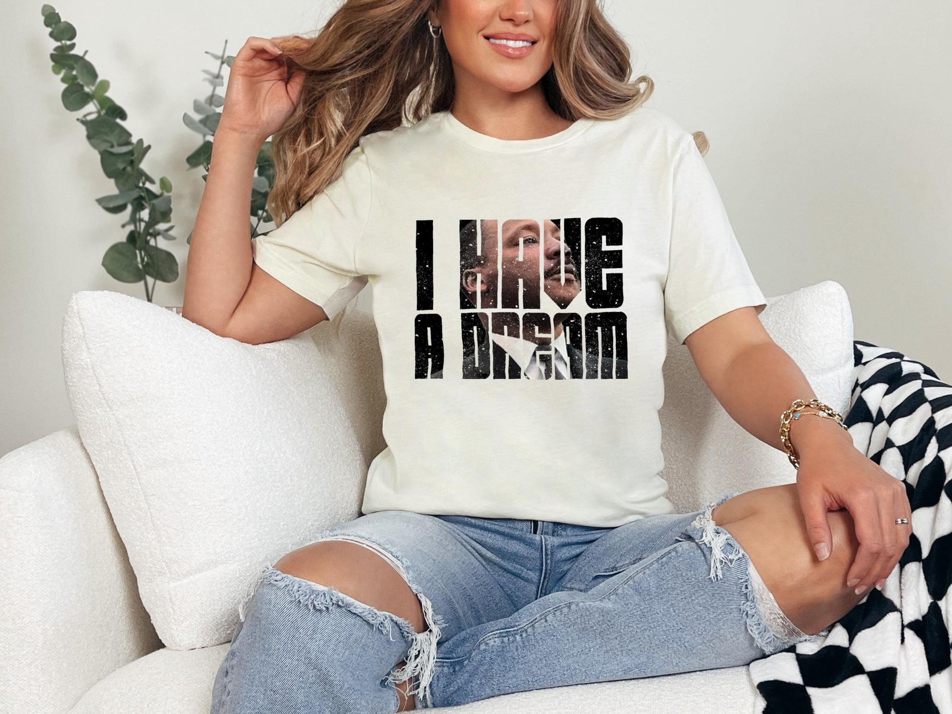 a woman sitting on a couch wearing a t - shirt that says i hug a