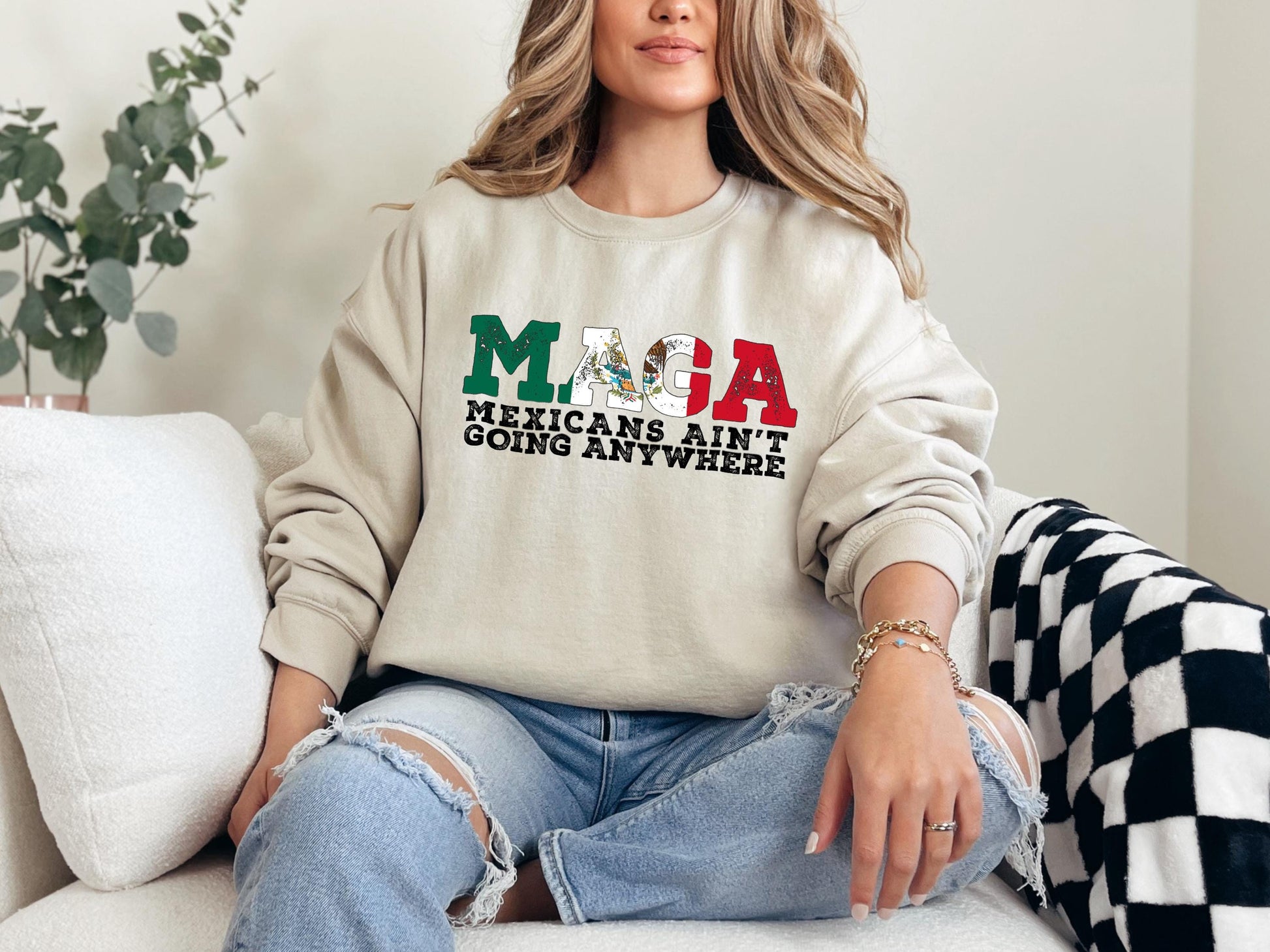 a woman sitting on a couch wearing a sweatshirt