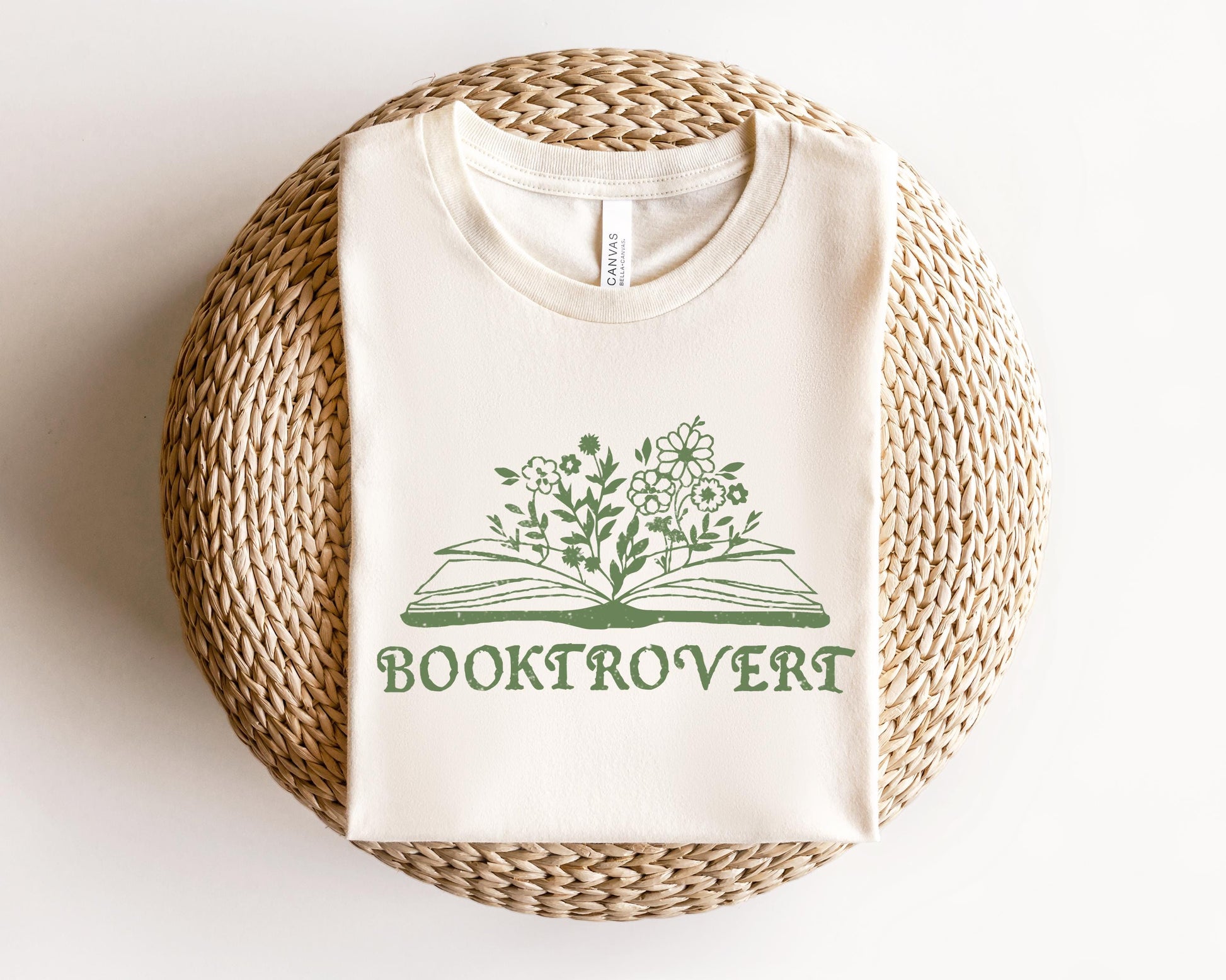 a white t - shirt with a book and flowers on it