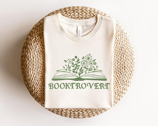 a white t - shirt with a book and flowers on it