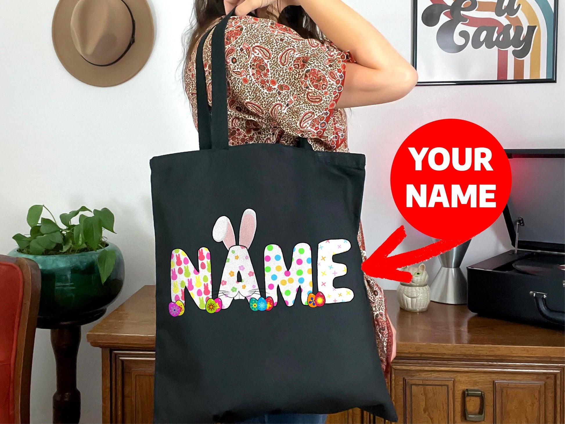 a woman holding a black bag with a name on it