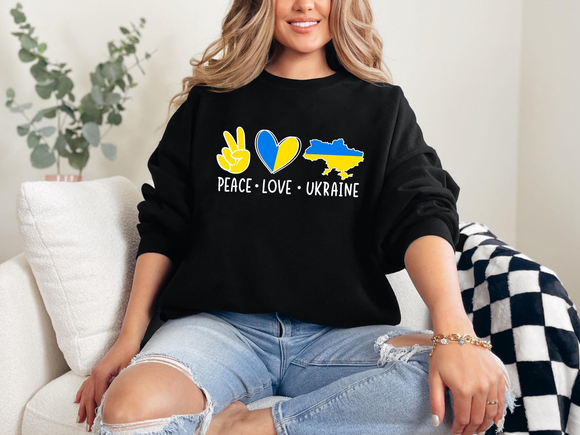 a woman sitting on a couch wearing a black sweatshirt