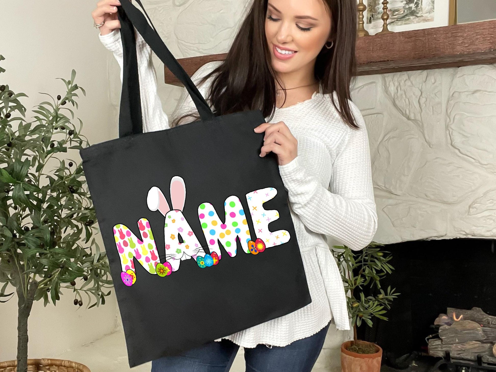 a woman holding a black bag with a name on it