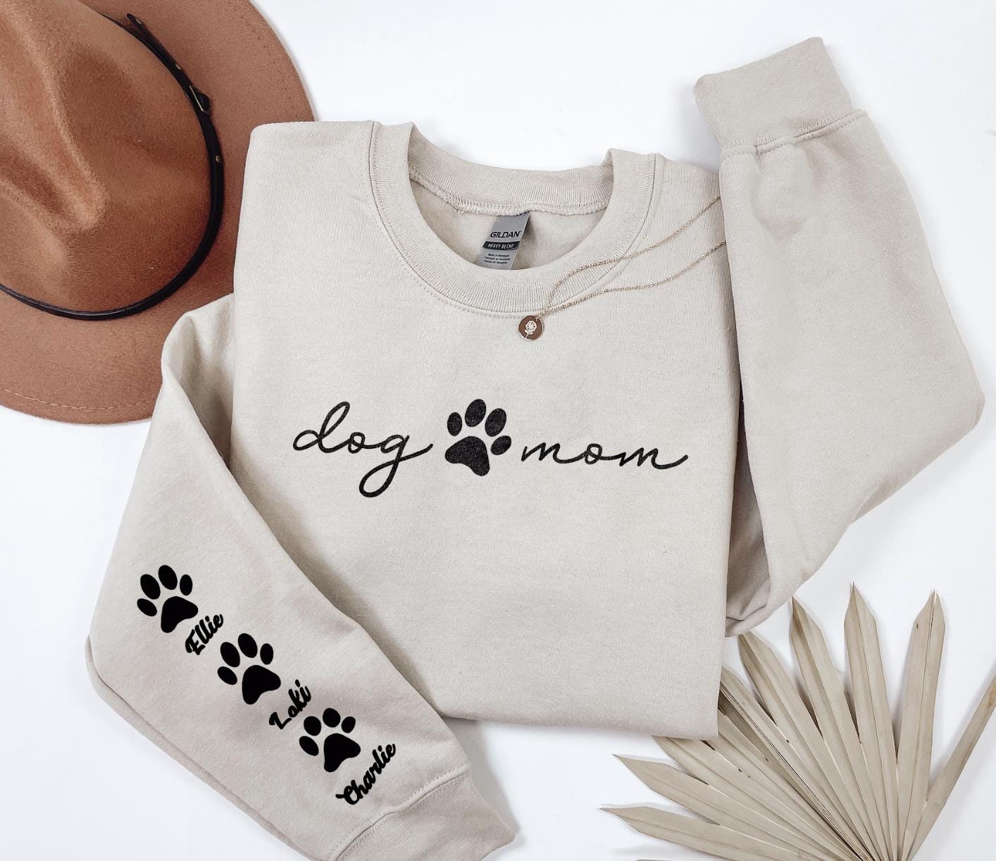 a dog mom sweatshirt with paw prints and a hat
